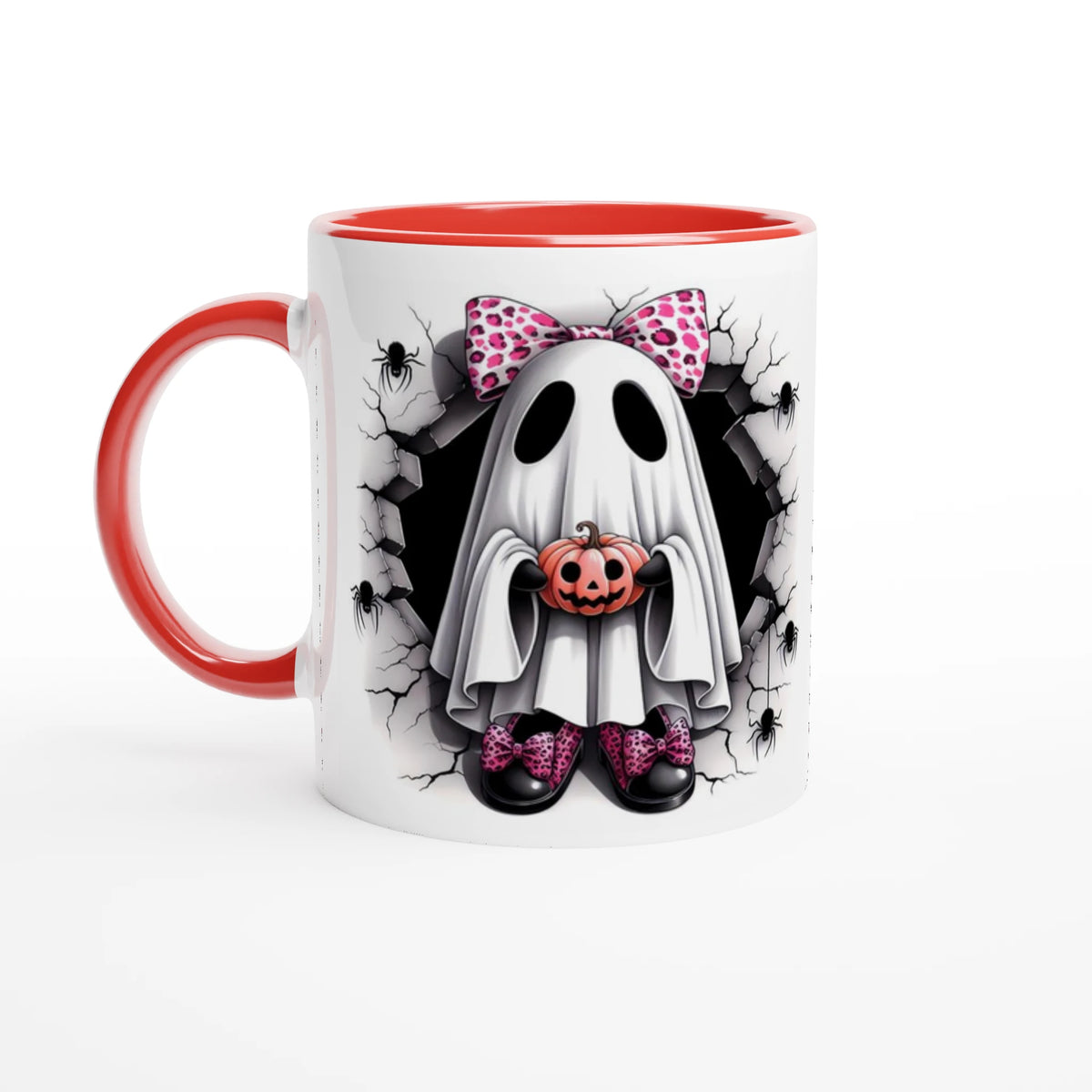 White mug with red handle and interior, featuring a ghost with a pink spotted bow holding a jack-o’-lantern, surrounded by cracked stone and spiders